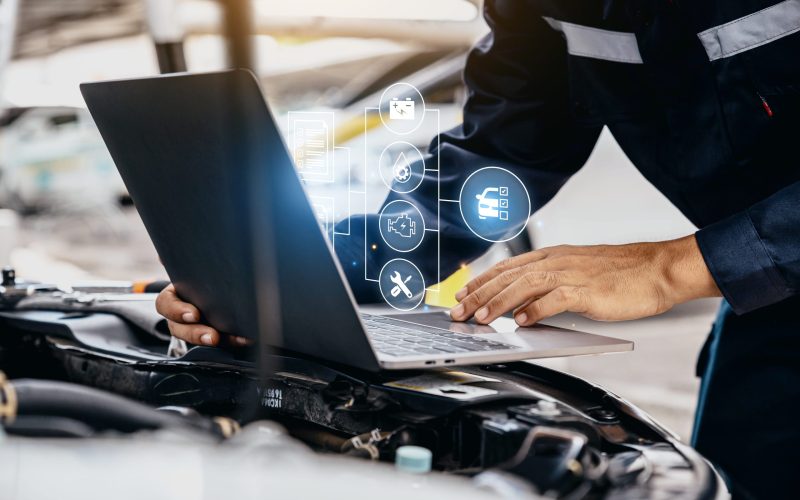 Mechanic using laptop checking up on car engines parts for fixing and repair, Smart service diagnostics software concept.